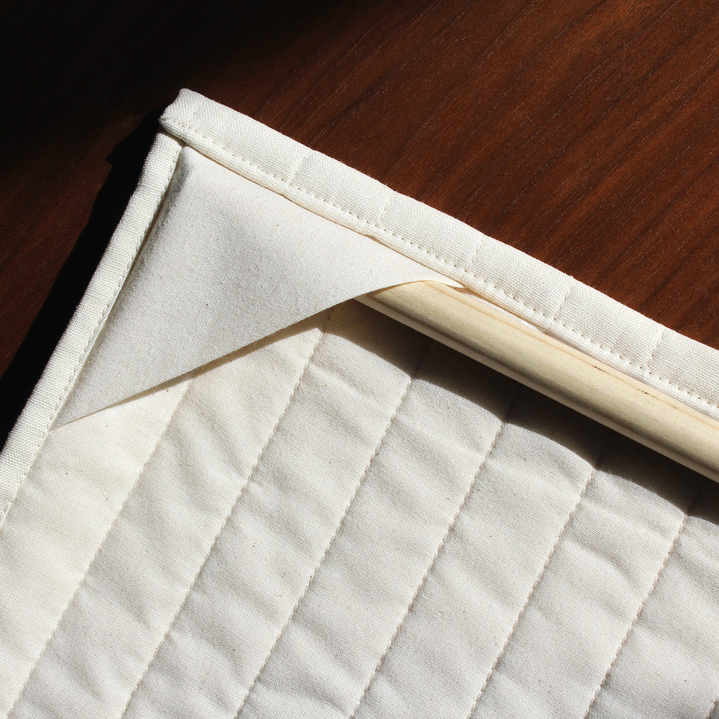 Close-up of a quilted wall hanging showing the back side and how to hang the quilt