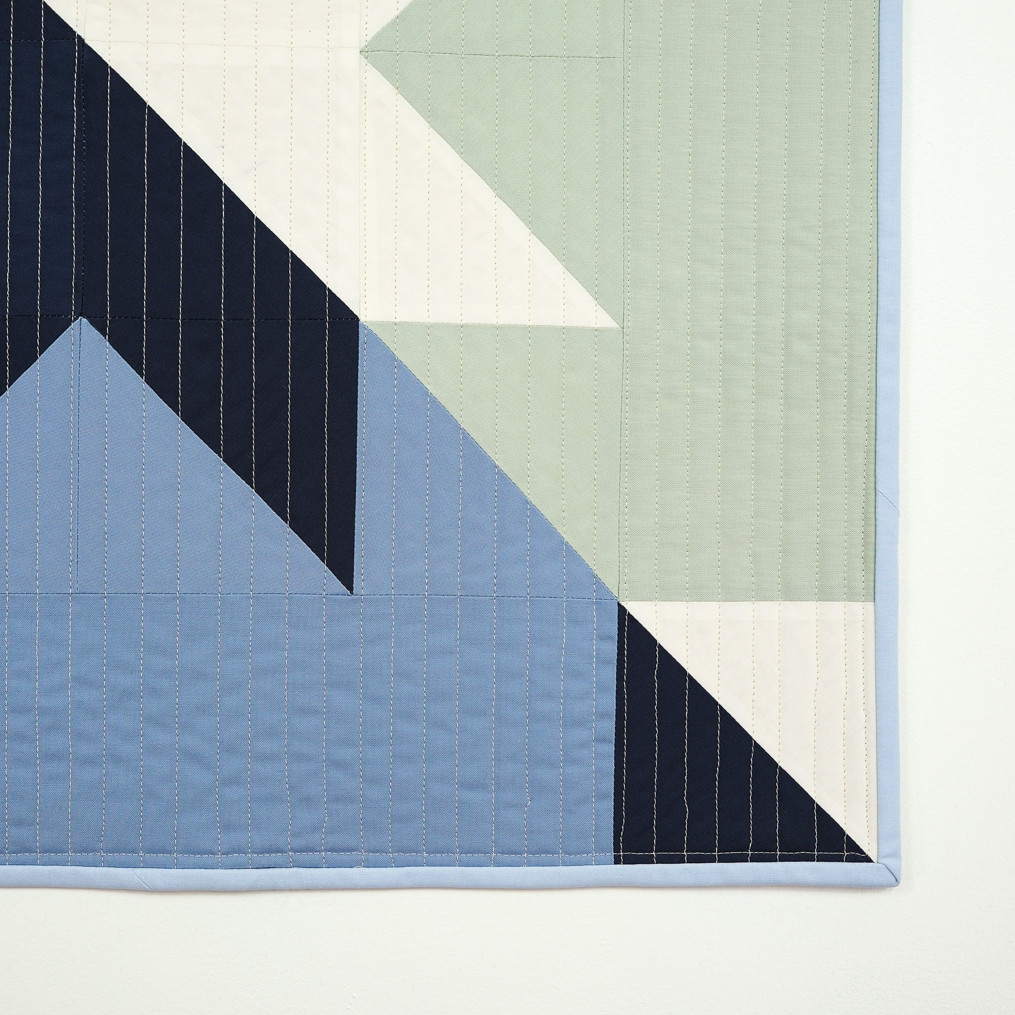 Close up of blue and green geometric quilt
