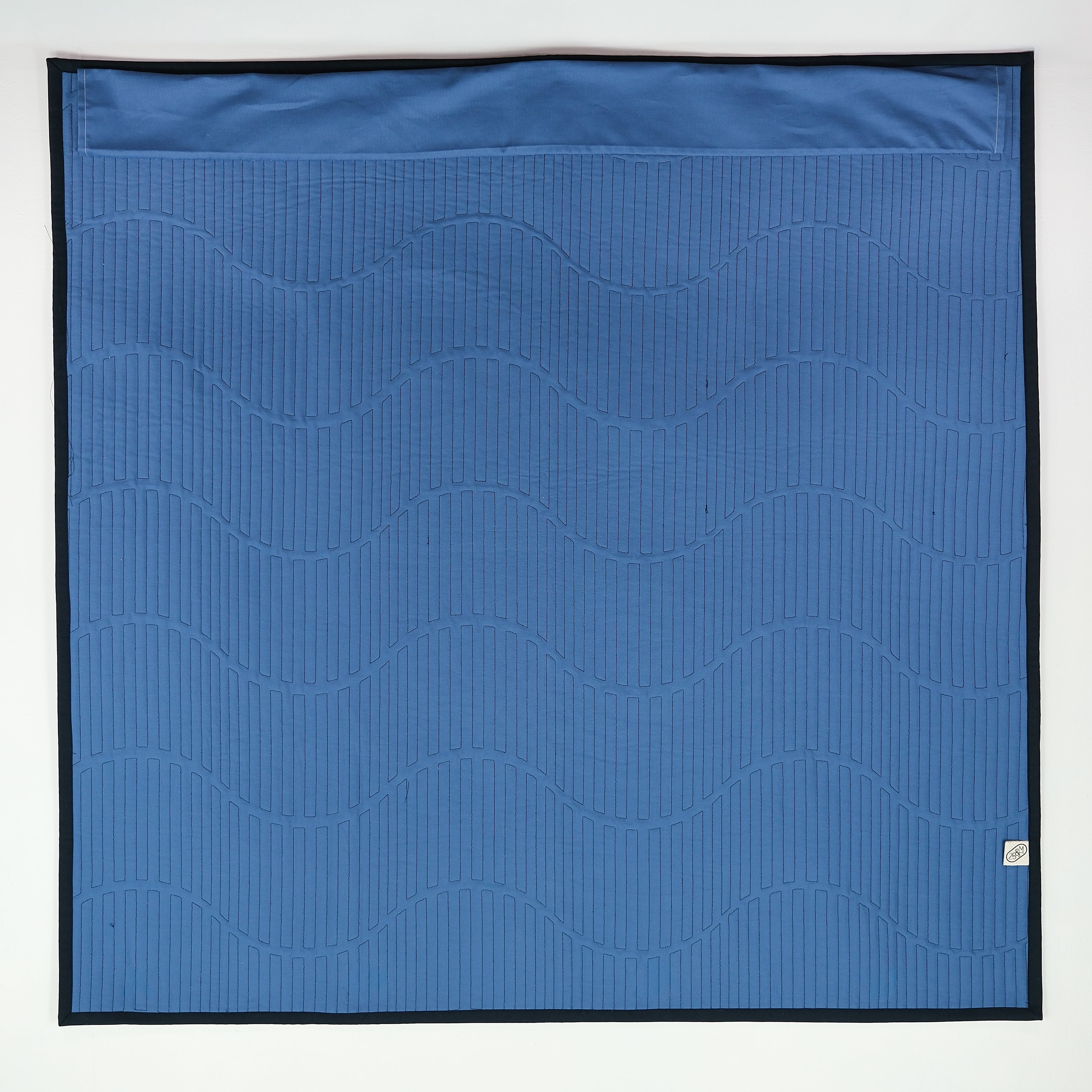 Blue quilt backing with wavy pattern on a white background