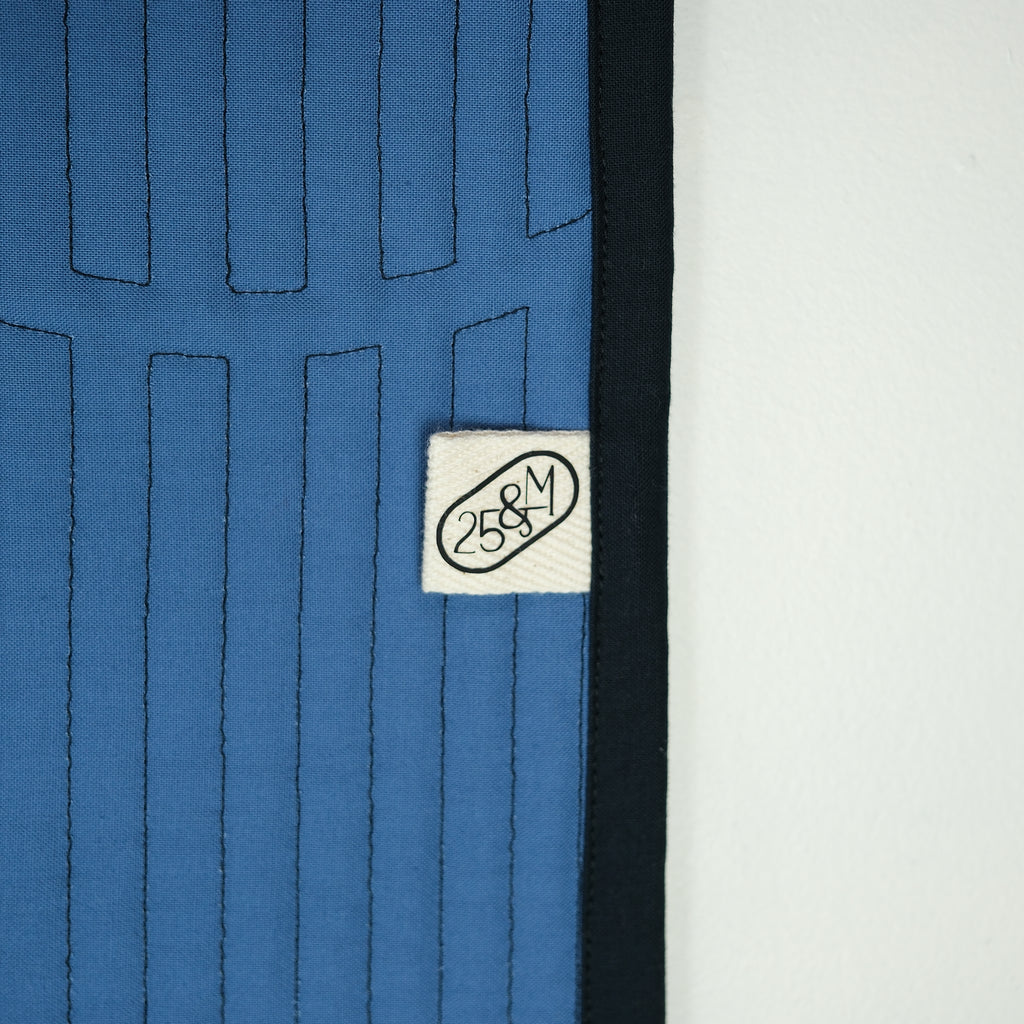 Close-up of a blue textured fabric with a white label featuring a logo and text.