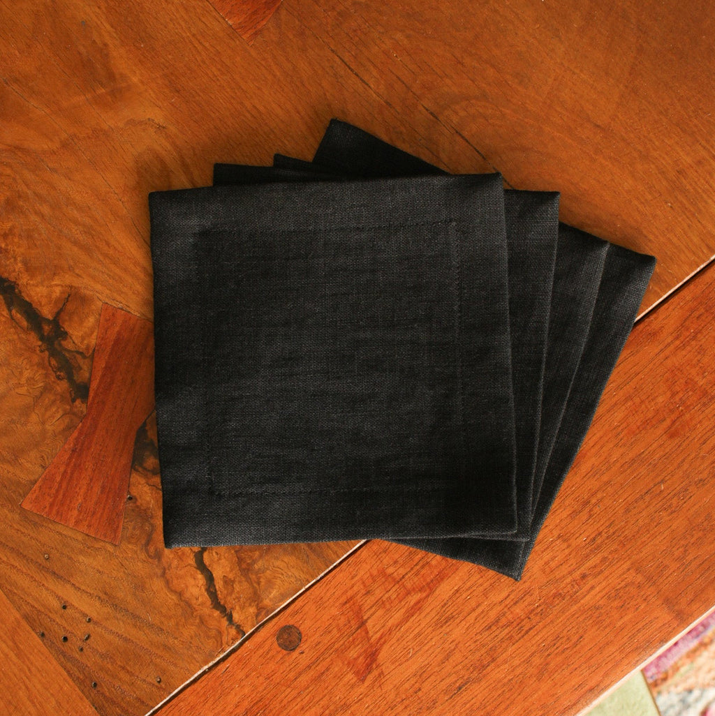 Stack of black linen napkins on a wooden surface