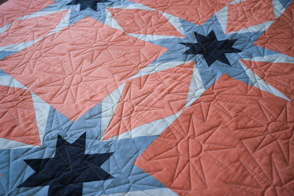 Quilt with star patterns in red, blue, and white