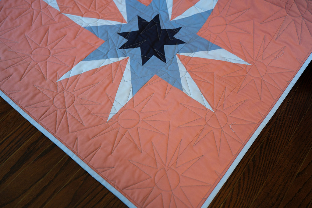 Quilt with star pattern on a wooden surface