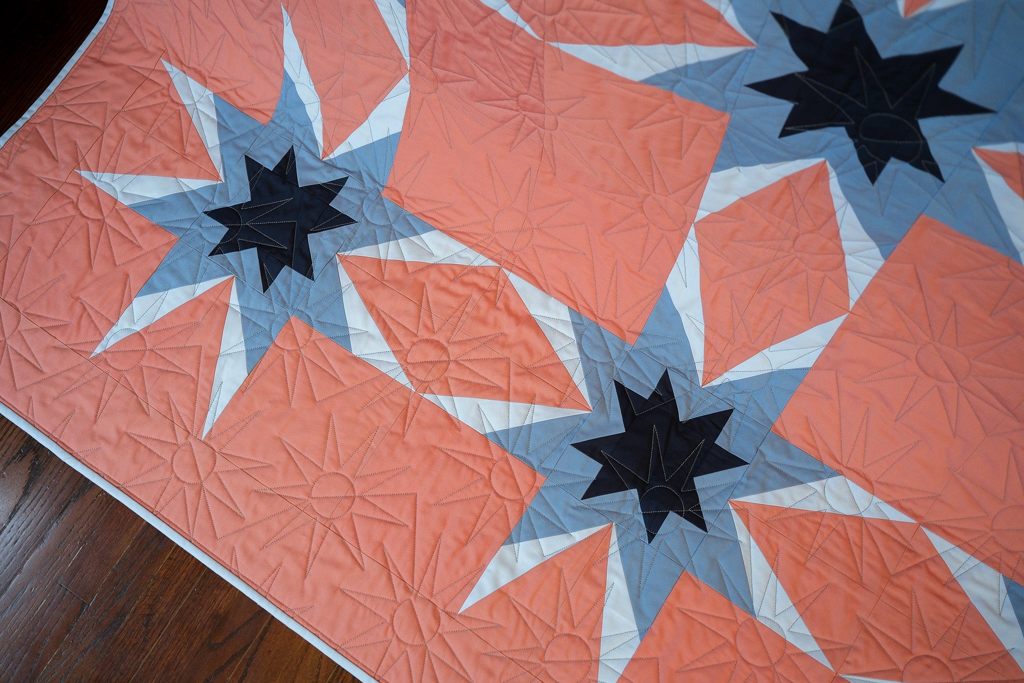 Quilt with star pattern on a wooden floor