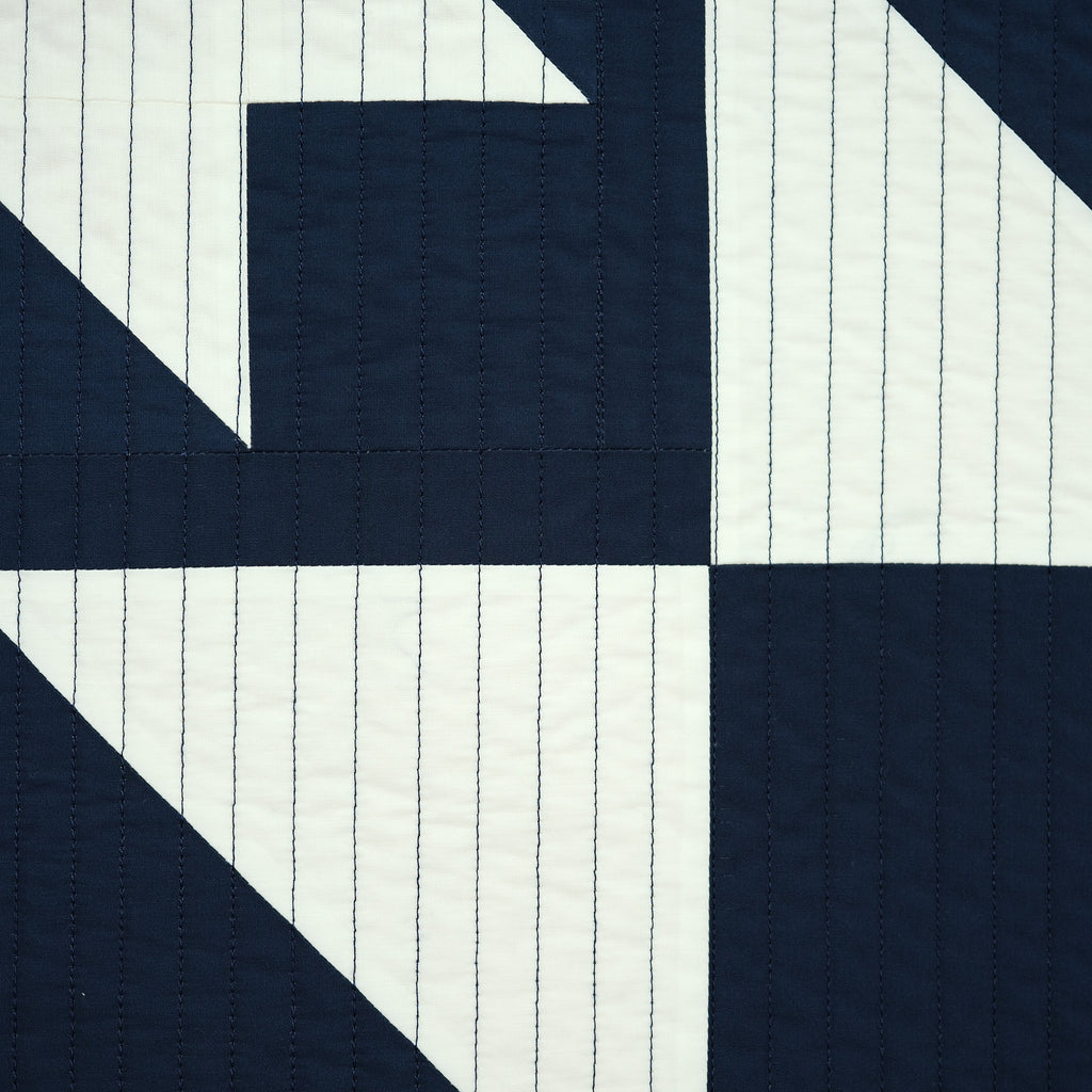 Navy and white quilt pattern with diagonal lines