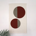 Geometric modern quilted wall hanging with a beige and rust color palette, with abstract circle design