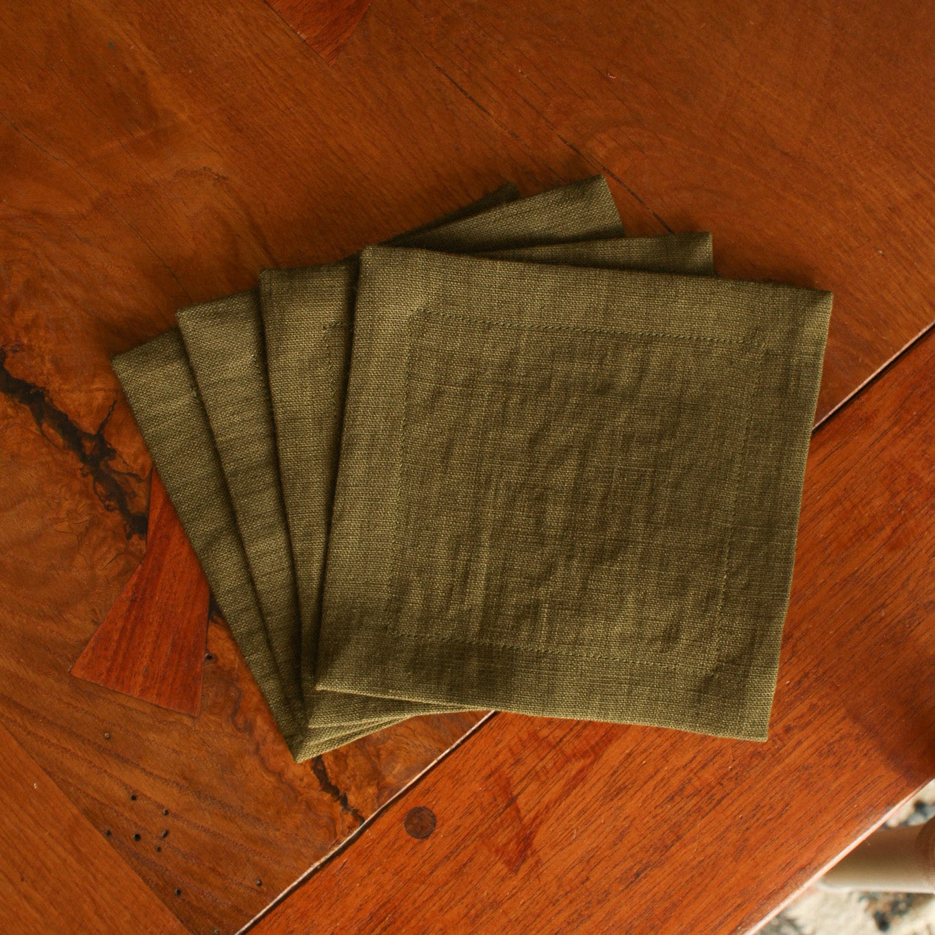 Set of green napkins on a wooden surface